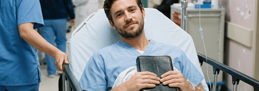 Handsome patient on stretcher with medications and Bible